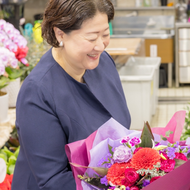 花束を眺めて微笑む代表取締役