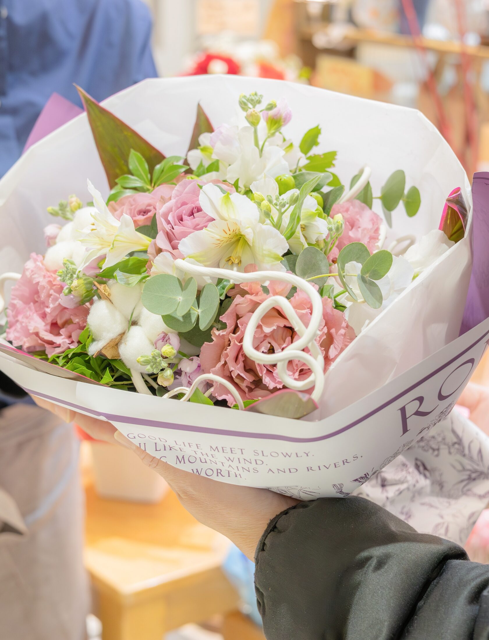 出来上がった花束をお客様へ手渡す店員